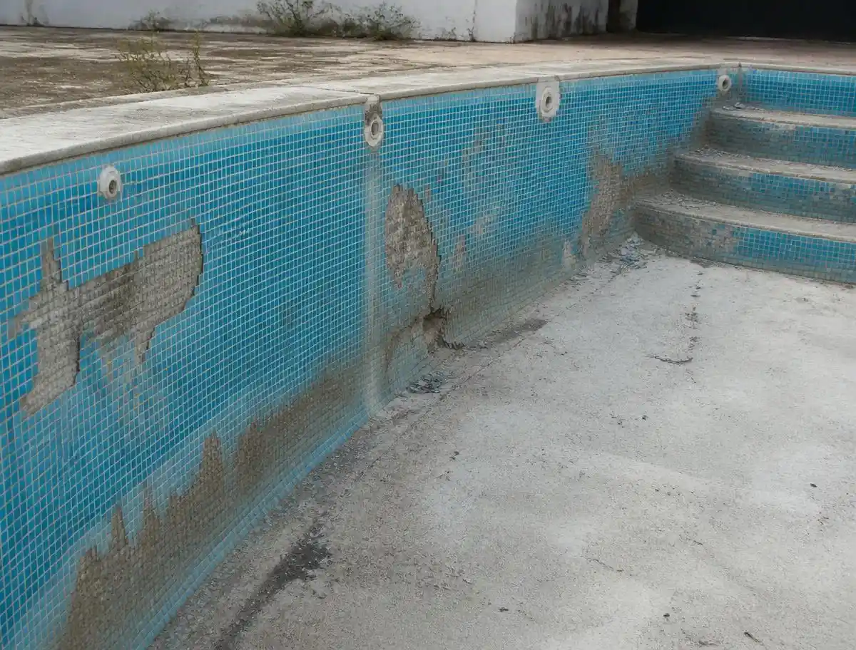 Piscine en gresite vieillissant avec carreaux décollés